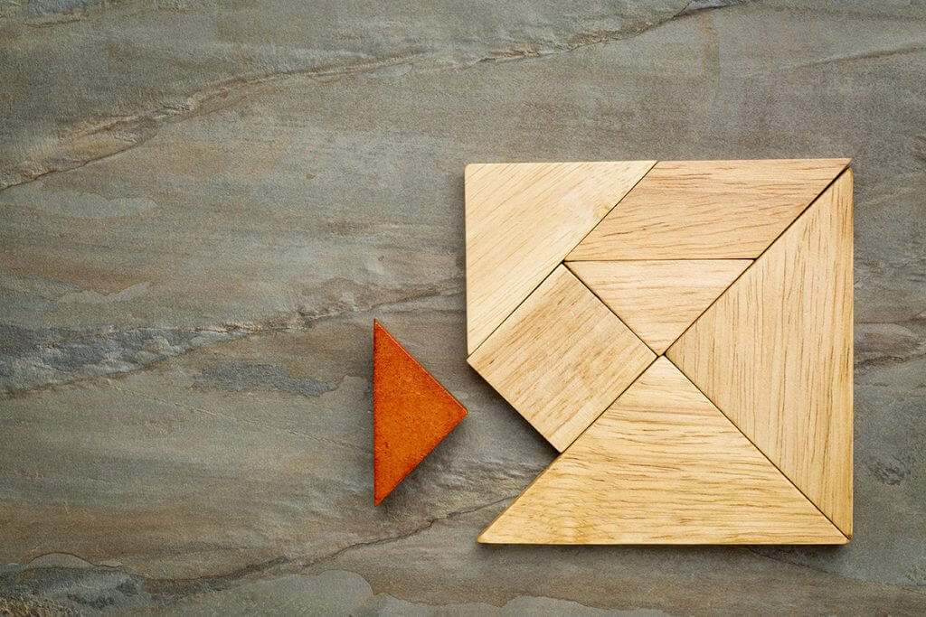 a missing piece in a square built from tangram pieces, a traditional Chinese puzzle game, slate rock background