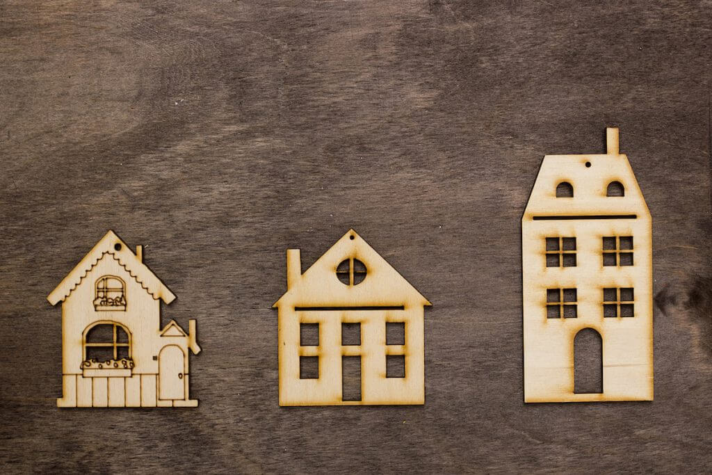 Models of houses with different heights on a wooden background