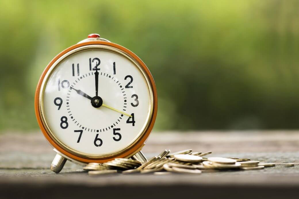 Alarm clock and money coins - time is money concept