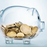 A see through piggy bank with money coins